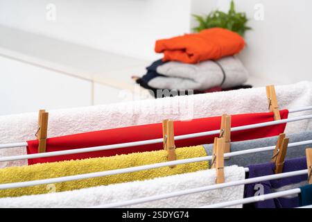 Close up of clean laundry hanging on drying rack indoors at house Stock Photo
