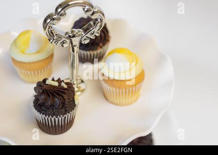 Chocolate and lemon cupcakes on a traditional cake stand for Easter and afternoon tea; concept for teatime, Birthdays and Mother's Day. Stock Photo