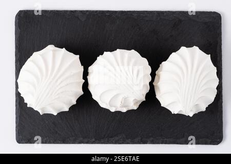 Three white zephyr on black slate plate Stock Photo