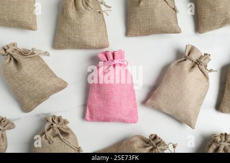 Different burlap bags on white marble table, flat lay Stock Photo