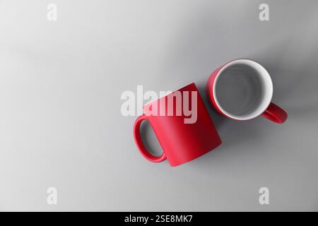 Two blank red mugs on light background, top view. Mockup for design Stock Photo