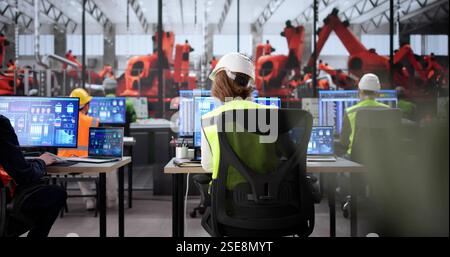 Team of diverse engineers using Scada software at automobile factory. Stock Photo