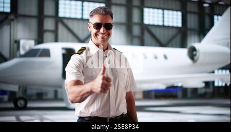 Private Jet Captain Pilot In Uniform Making Thumbs Up Gesture Stock Photo