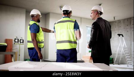 Businessman and construction engineer team up at apartment site renovation. Stock Photo