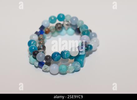 A beautiful three-strand bracelet made of handmade blue mineral gemstone beads, highlighting natural beauty, set against a clean white background Stock Photo