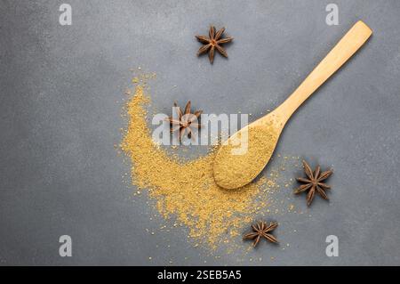 Anise star seed and anise spice powder in wooden spoon on grey rustic backdrop ( Pimpinella anisum ), top view copy space Stock Photo