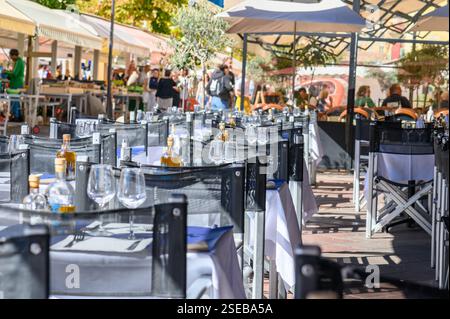 View of the terrace of a restaurant with many set tables at lunchtime,Nice, Cotes d'Azur, France Stock Photo