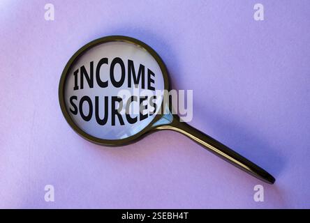 Income Sources symbol. Magnifying Glass with Concept word Income Sources. Beautiful purple background. Business and Income Sources concept. Copy space Stock Photo