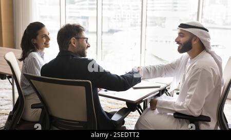 Two multicultural European and Arabian men engaged in firm handshake Stock Photo