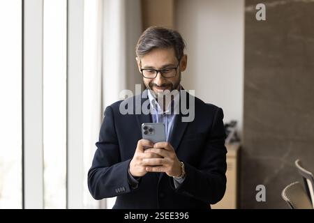 Businessman responding to client or colleague using smartphone Stock Photo