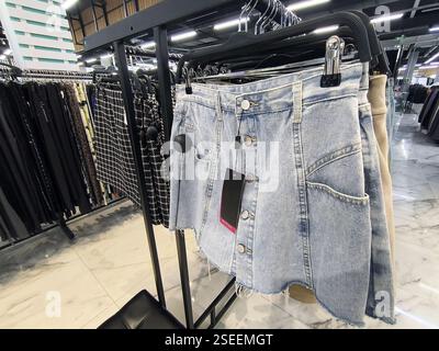 Denim mini skirt display on rack in fashion retail clothing store. Stock Photo