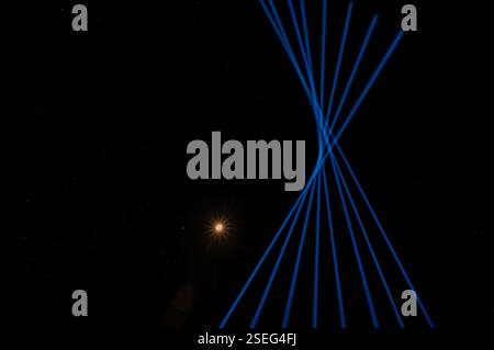 blue laser beams in the sky next to the moon at Copenhagen Light Festival. Denmark, February 6, 2025 Stock Photo