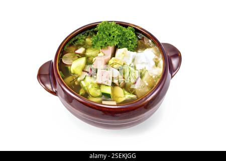 Cold soup okroshka from sausage, potatoes, eggs, radish, cucumber, greens and kvass in clay bowl isolated on white background Stock Photo