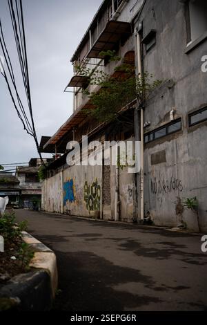 building on the side of the road with old walls covered in graffiti Stock Photo