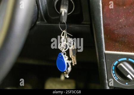 car ignition key on the chain with other keys in a lock, no people Stock Photo