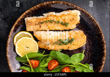 Roast Cod fish fiilets, white fish meat on plate with salad isolated on ...