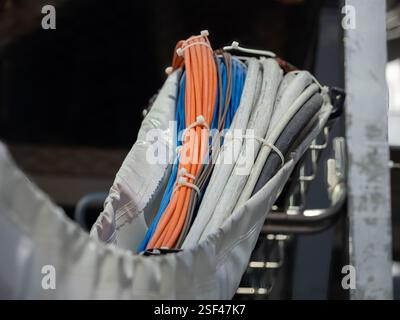 Geneva, Switzerland - February 5, 2025: A collection of neatly organized electrical cables in various colors, including orange, blue, and gray, secure Stock Photo