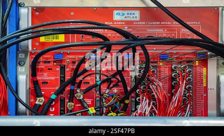 Geneva, Switzerland - February 5, 2025: View of a complex electrical panel in CERN, ATLAS, featuring multiple red circuit boards, wires, and connector Stock Photo