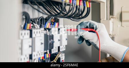 Electrical engineer checking the operation of electrical control cabinet, maintenance concept. Stock Photo