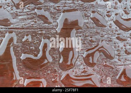 abstract backgrounds, water on dark brown, liquid pools, reflections, coalescing, brown timber Stock Photo