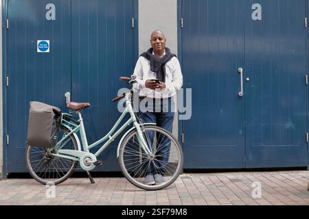 A senior black male gets on his bike to explore the city. Stock Photo