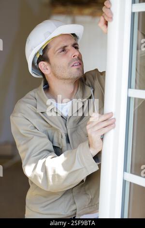 service man installing window with screwdriver Stock Photo