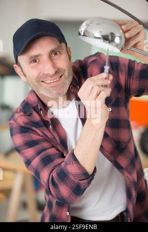 man using screwriver on decorative lamp Stock Photo