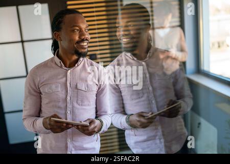 Relaxed smiling african american man holding digital tablet computer using apps Stock Photo