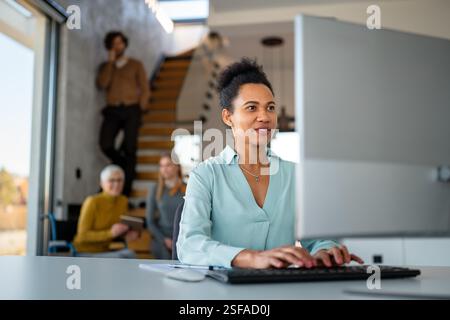 Business woman working on laptop computer reading financial document report in office Stock Photo