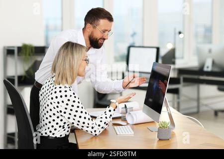 Technicians making digital engineering drawing on computer at desk in office Stock Photo