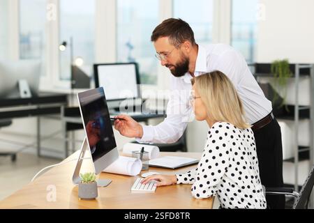 Technicians making digital engineering drawing on computer at desk in office Stock Photo