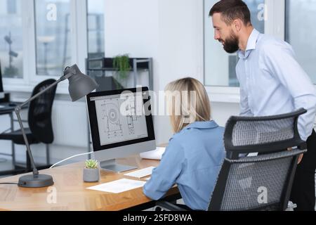Technicians making digital engineering drawing on computer at desk in office Stock Photo