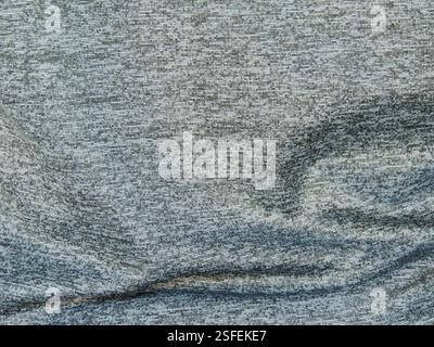grey variegated fabric with wavy crumpled surface as drapery background or canvas texture, synthetic silver material with short line pattern Stock Photo
