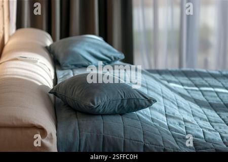 a made up double bed in clean and tidy bedroom, morning scenery Stock Photo