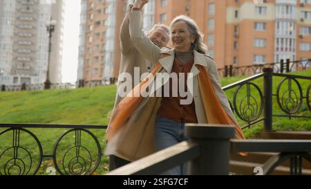 Caucasian mature middle-aged woman man married couple dance together slow movement retired wife husband partners love romantic dancing male spin Stock Photo