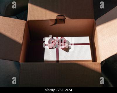 a gift box inside the open cardboard box, daylight shot, no people Stock Photo
