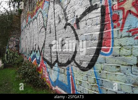Graffiti covering a brick wall along the banks of Regents Canal, London Stock Photo