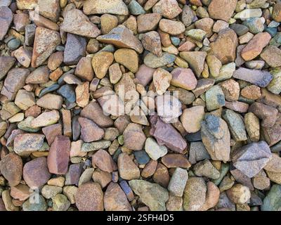 A closeup of colourful, weathered stones on a beach. Stock Photo
