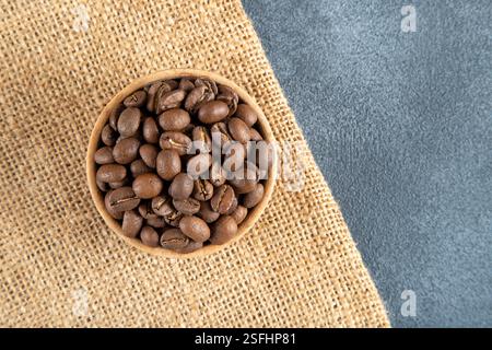 Roasted coffee beans in a bowl on a coffee sack. Stock Photo