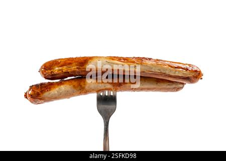 A fork with two grilled sausages. Sausage on a fork on a white background. Stock Photo