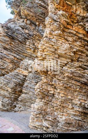 Layered rock texture in Budva, Montenegro. Sedimentary rocks with rugged surface of gray and ...