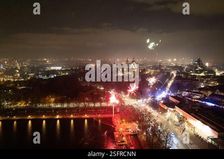 A breathtaking nighttime cityscape featuring vibrant fireworks lighting up the sky and illuminated streets below Stock Photo