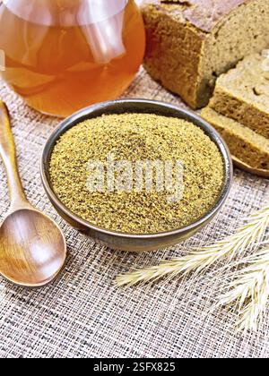 Malt in a bowl, spoon, bread, kvass in a jug, spikelets on the background of wicker brown napkin Stock Photo
