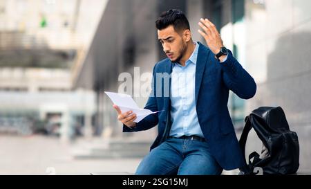 Emotional arabic guy young entrepreneur reading mail, copy space Stock Photo