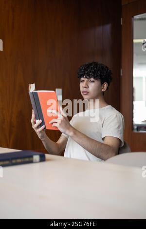 A university student reviewing notes, preparing for exams. Perfect for themes of education, study sessions, academic dedication, and university life. Stock Photo