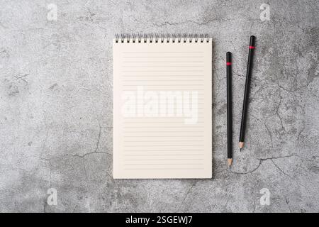 Top view of notebook and pencil on stone table Stock Photo