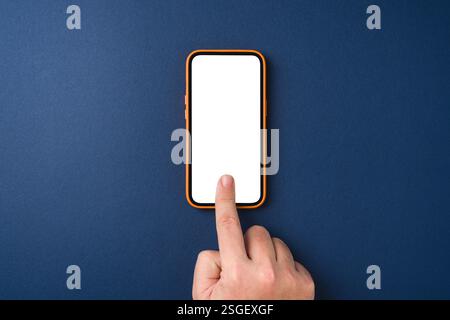 Man hand touching screen of smartphone with index finger on blue background Stock Photo
