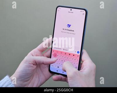 Travnik, Bosnia and Herzegovina, 02.08.2025: Close up of Asian female hands using DeepSeek app chat on phone to solve a reasoning problem on an Stock Photo