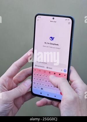 Travnik, Bosnia and Herzegovina, 02.08.2025: Close up of Asian female hands using DeepSeek app chat on phone to solve a reasoning problem on an Stock Photo