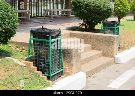 Green garbages bin near side walk at publick. Public trash on the side of the road. Infectious control concept. Stock Photo